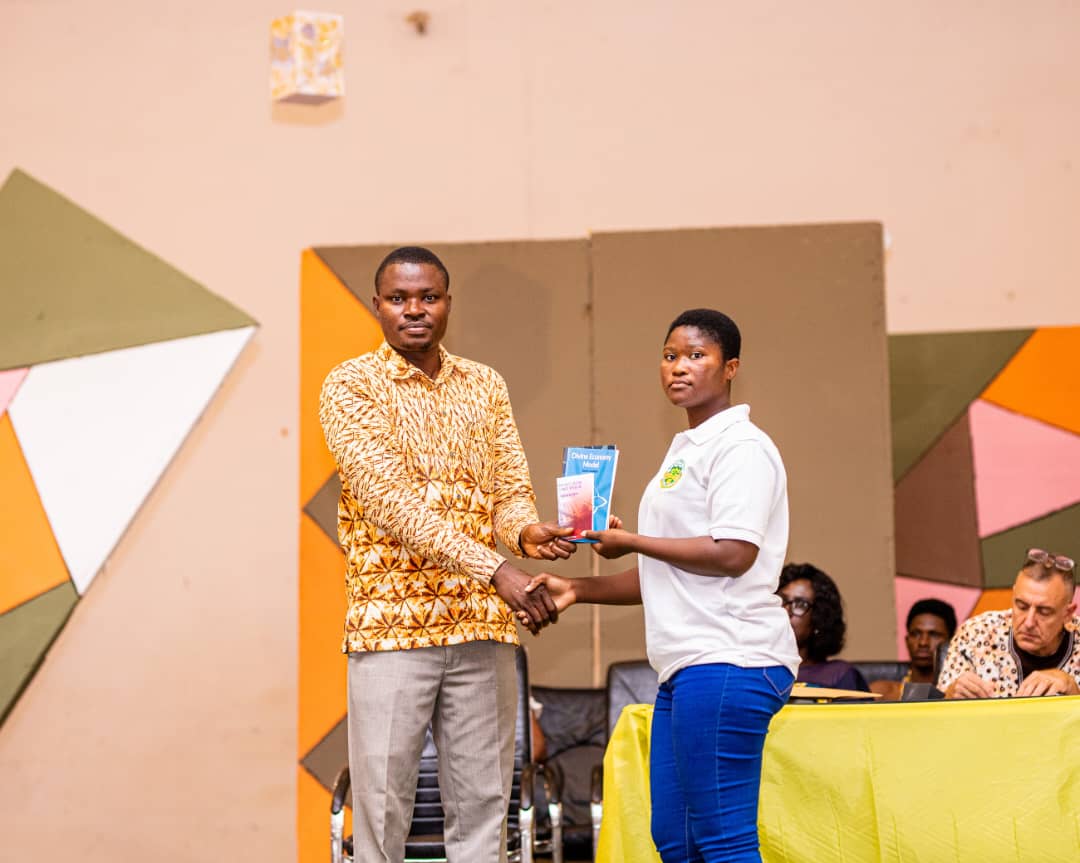 Eric Coffie, ILEE’s president presenting books to the winner of the essay competition