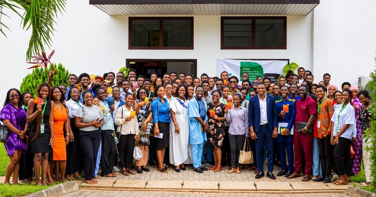 Large group of students and professionals posing outside a conference venue during a campus summit event in Ghana