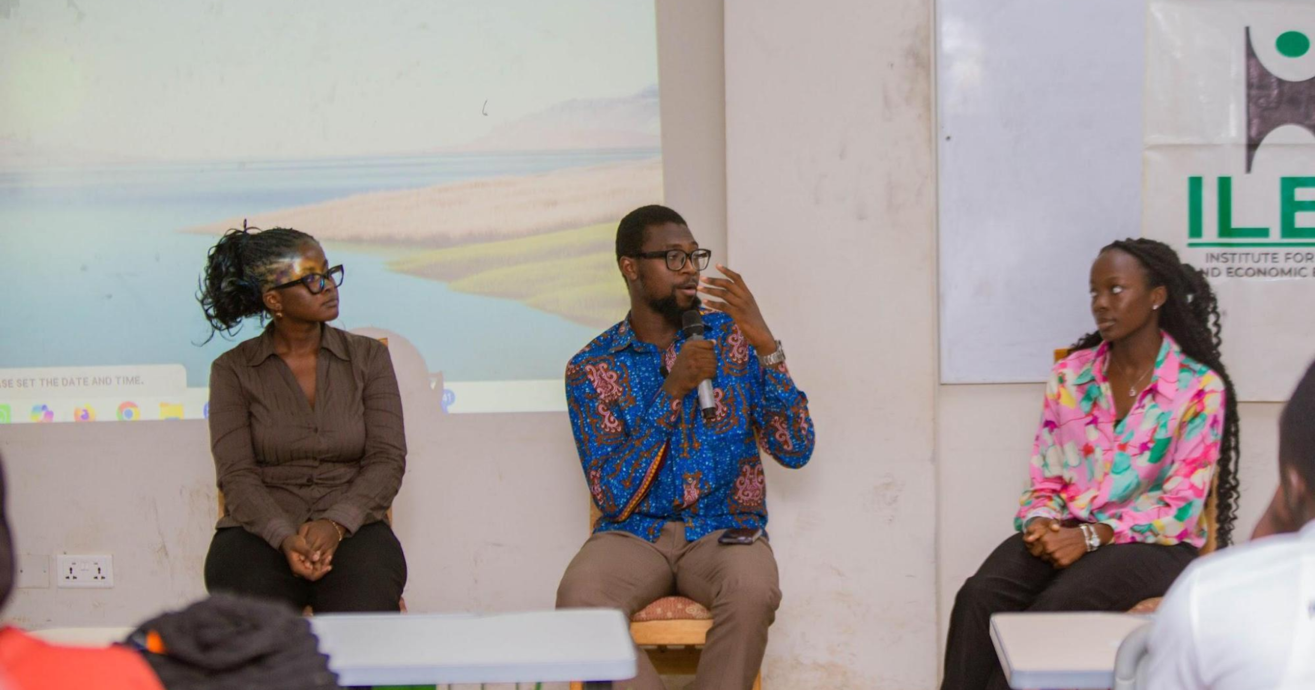 Three panelists participate in a discussion during an Institute for Liberty and Economic Education (ILEE) event as attendees listen and engage.